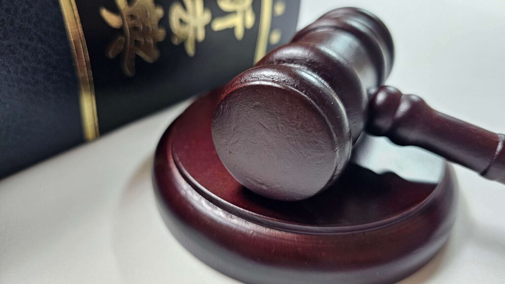 법원 판결에 사용되는 판사봉과 법전이 함께 놓여있는 사진